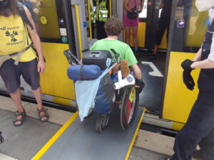 Rollstuhlfahrerin rollt über eine Rampe in die Bahn