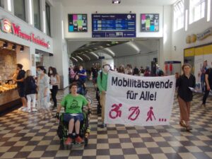 Die Gruppe laeuft und rollt durch den Gang, mit Banner.