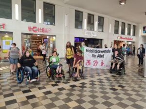 Gruppenfoto in der Bahnhofshalle Köln Messe Deutz mit Banner 'Mobilitätswende für Alle!'
