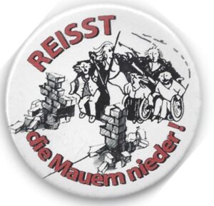 Button mit Zeichnung: Reisst die Mauenr Nieder! und Zeichnung von Mauerresten und Menschen die diesen angegriffen haben, mit und ohne Rollstuhl